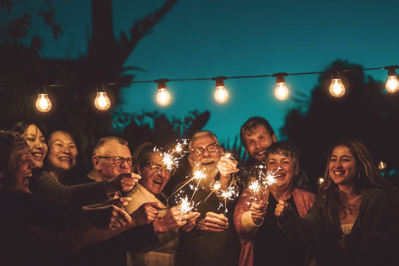 happy family celebrating with sparkler at night party